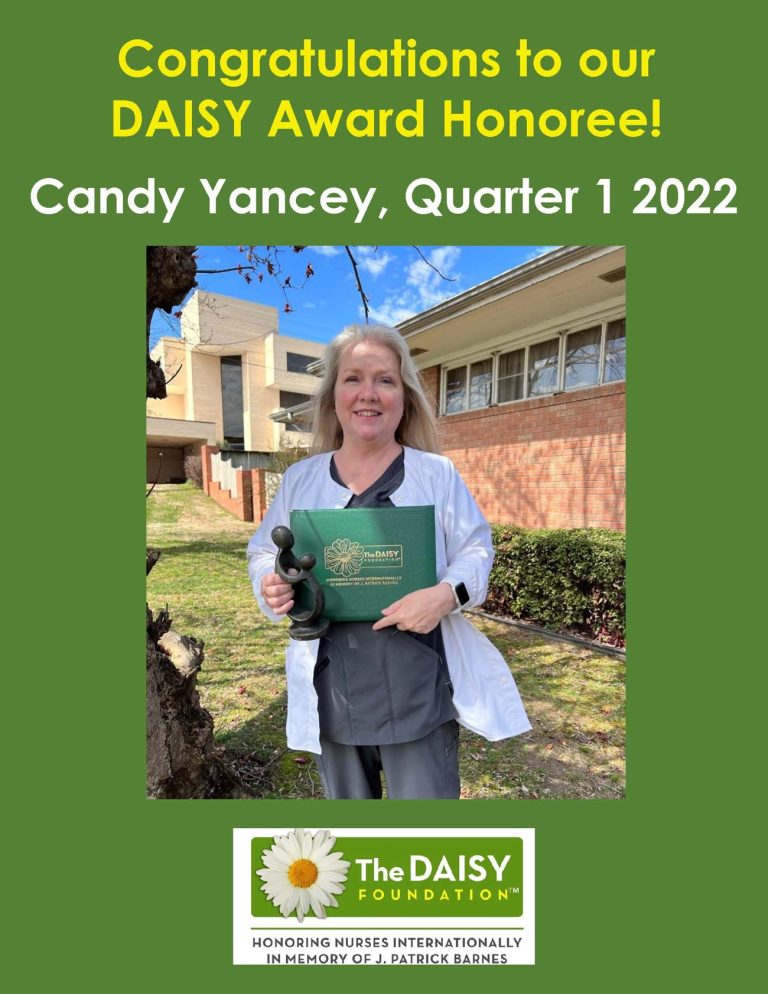 A woman posing with an award from the Daisy Foundation