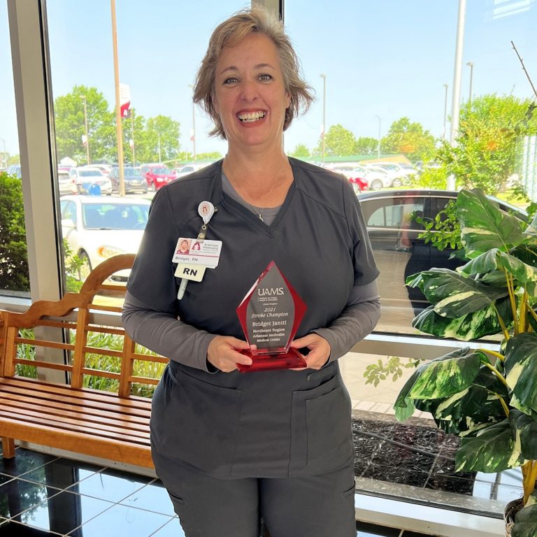 A woman posing with an award