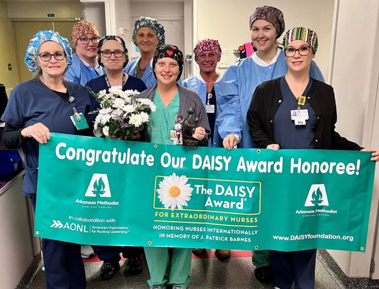 A group of nurses posing with an award from the Daisy Foundation
