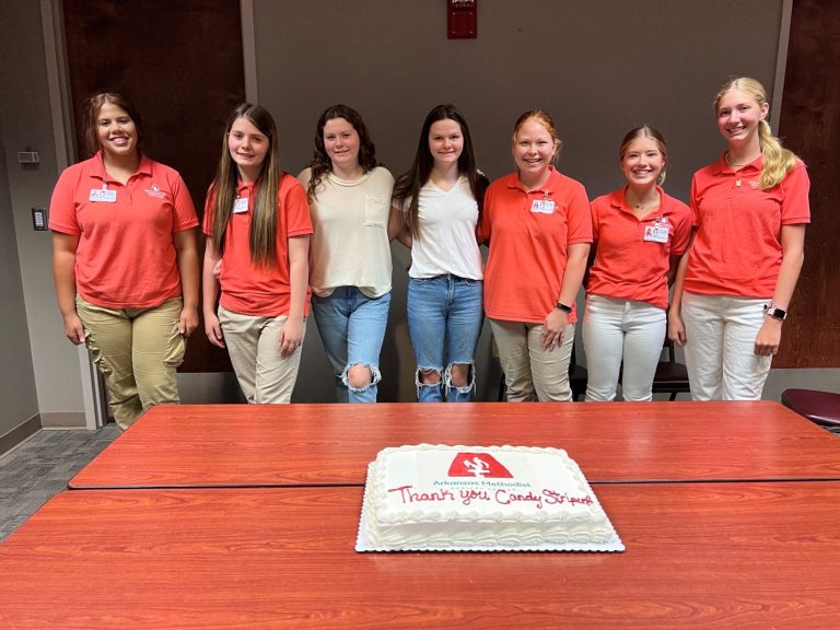 A picture of a group of girls with a cake