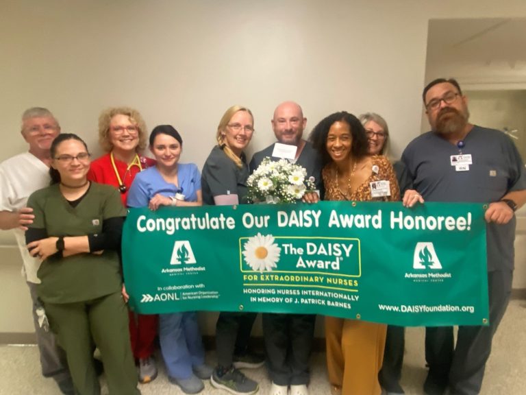 A group of people posing with an award from the Daisy Foundation