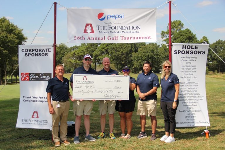 A group posing with a check