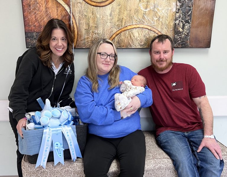A group holding the first baby of the new year